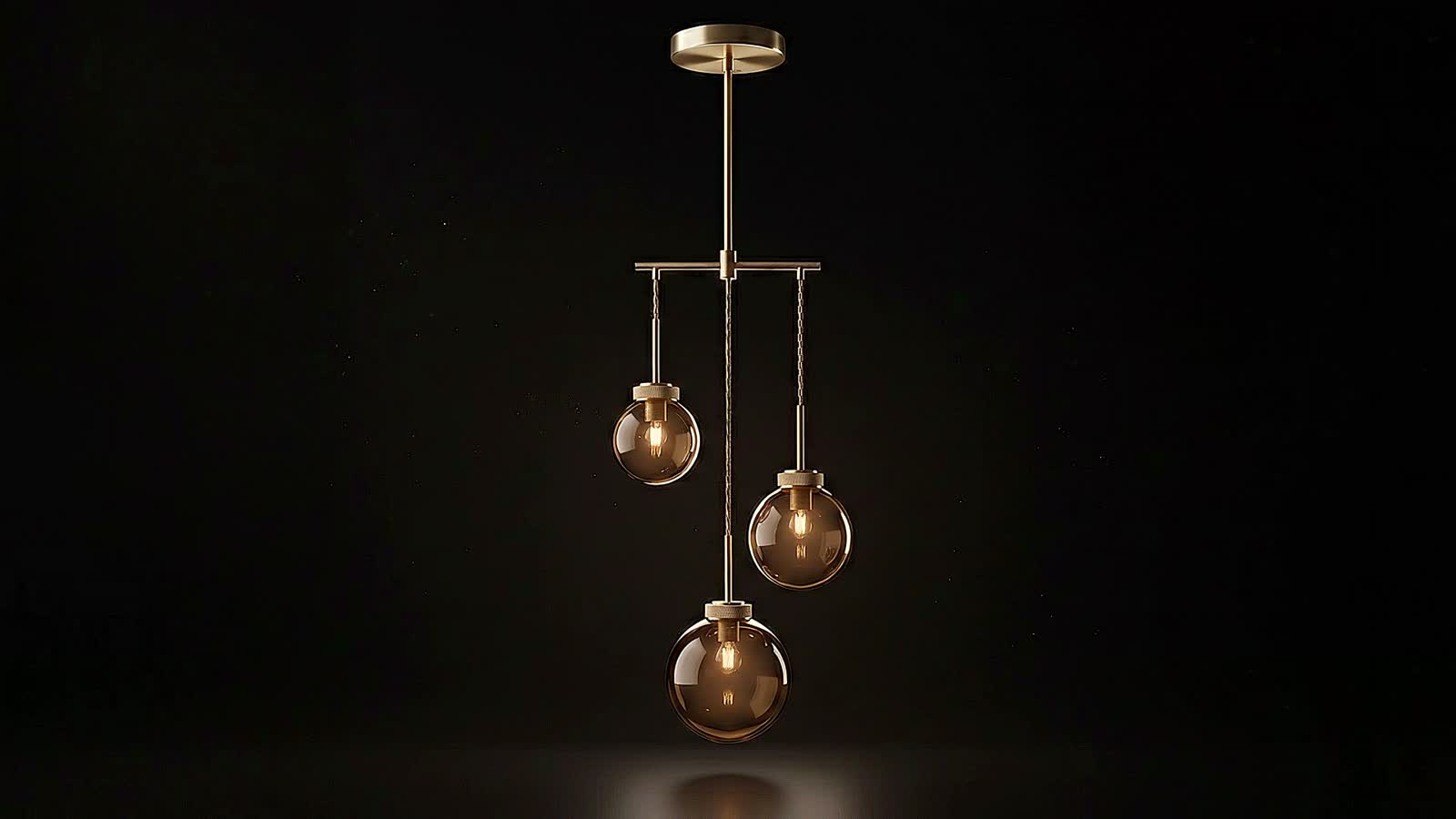 The Meridian pendant — hand-spun brass and three hand-blown amber glass globes.